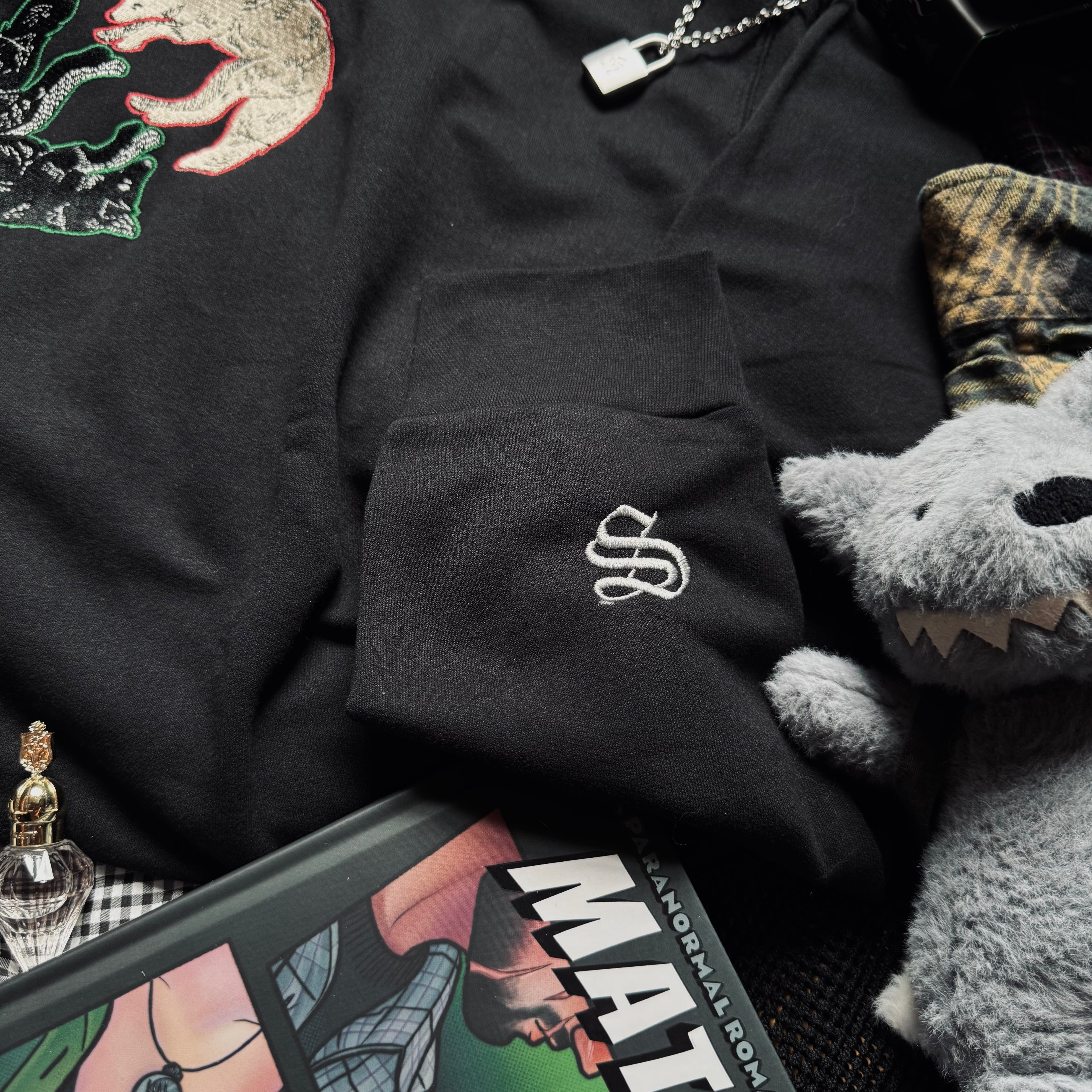 Black sweatshirt with S embroidered design.