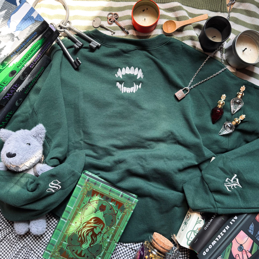 Green sweatshirt with bite embroidered design.