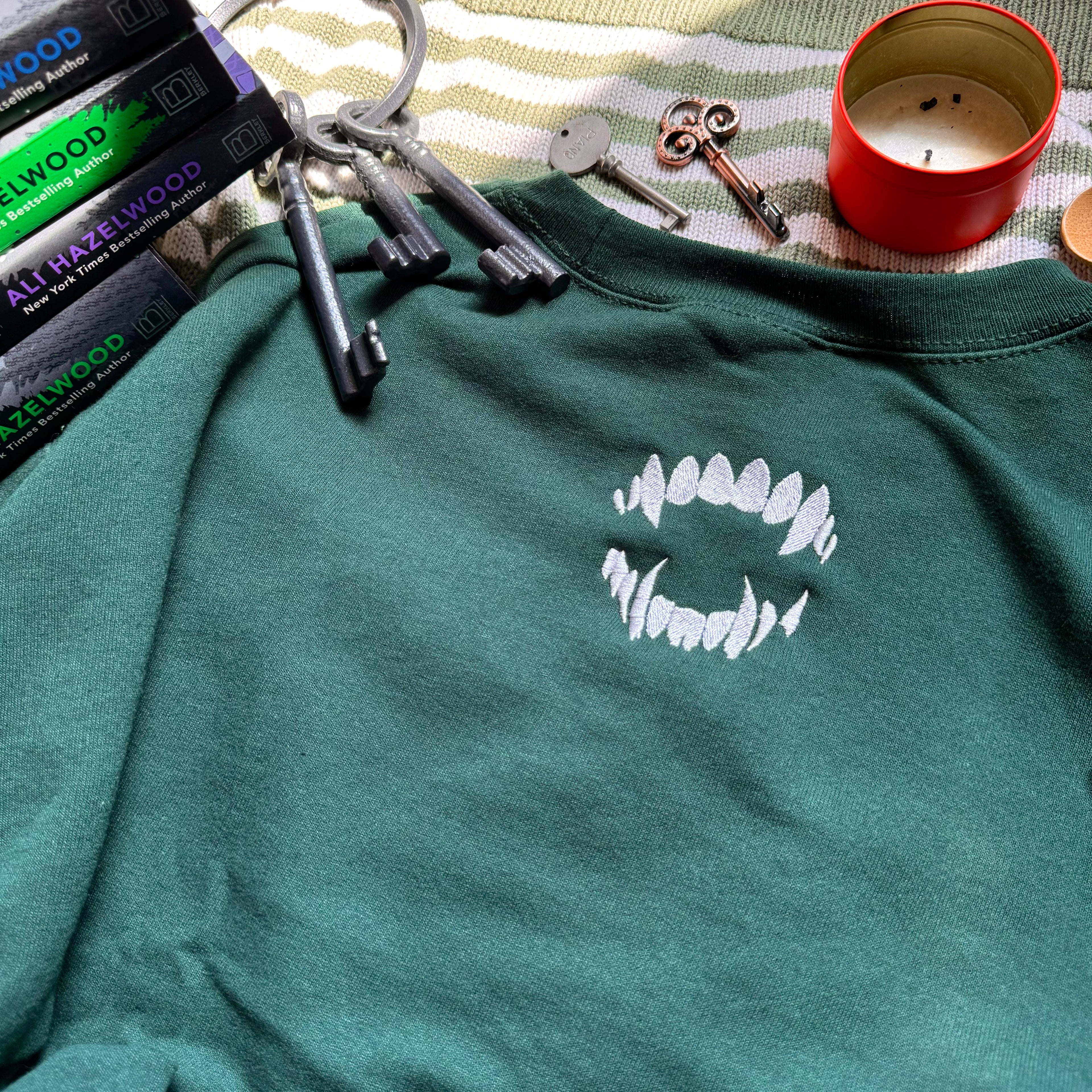 Green sweatshirt with bite mark embroidered design.