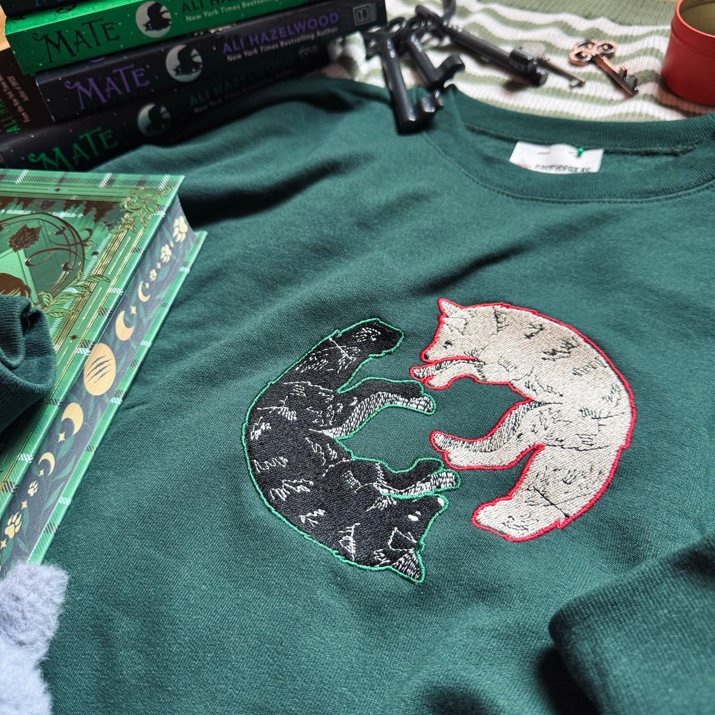 Green sweatshirt with dual wolf embroidered design.
