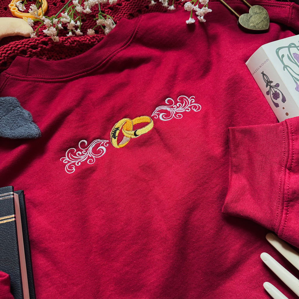 Red shirt with embroidered rings and decorative elements on a table.