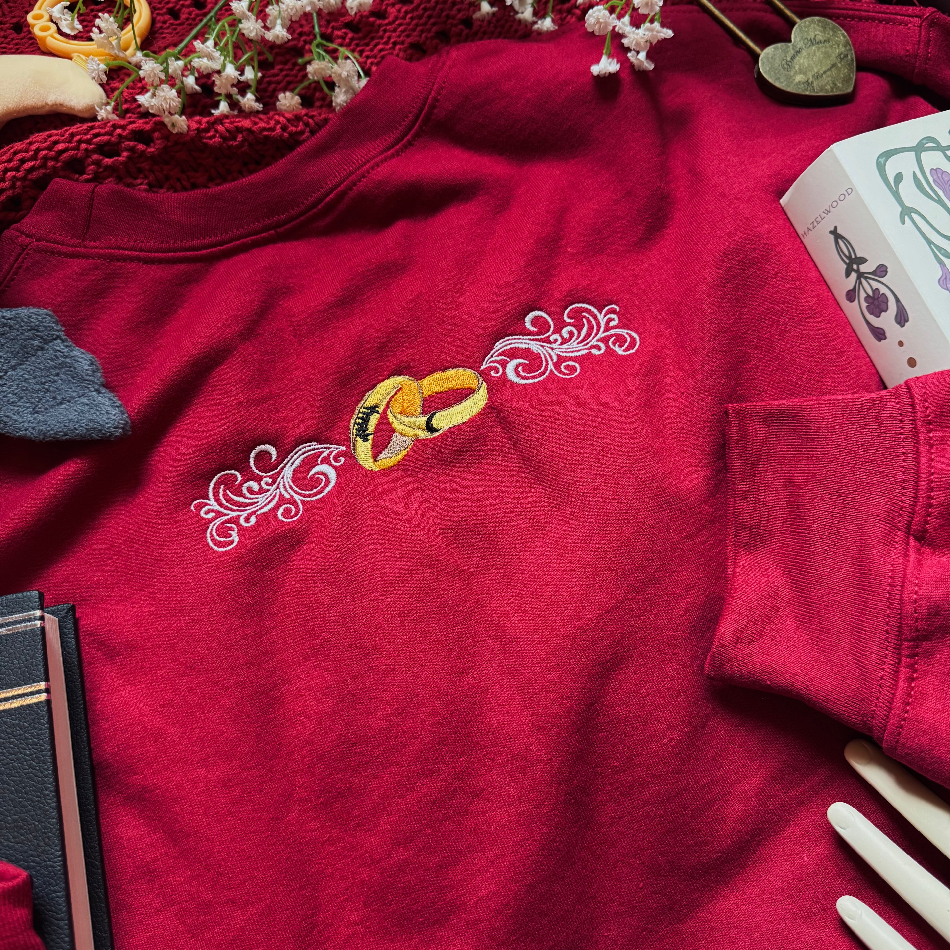 Red shirt with embroidered rings and decorative elements on a table.
