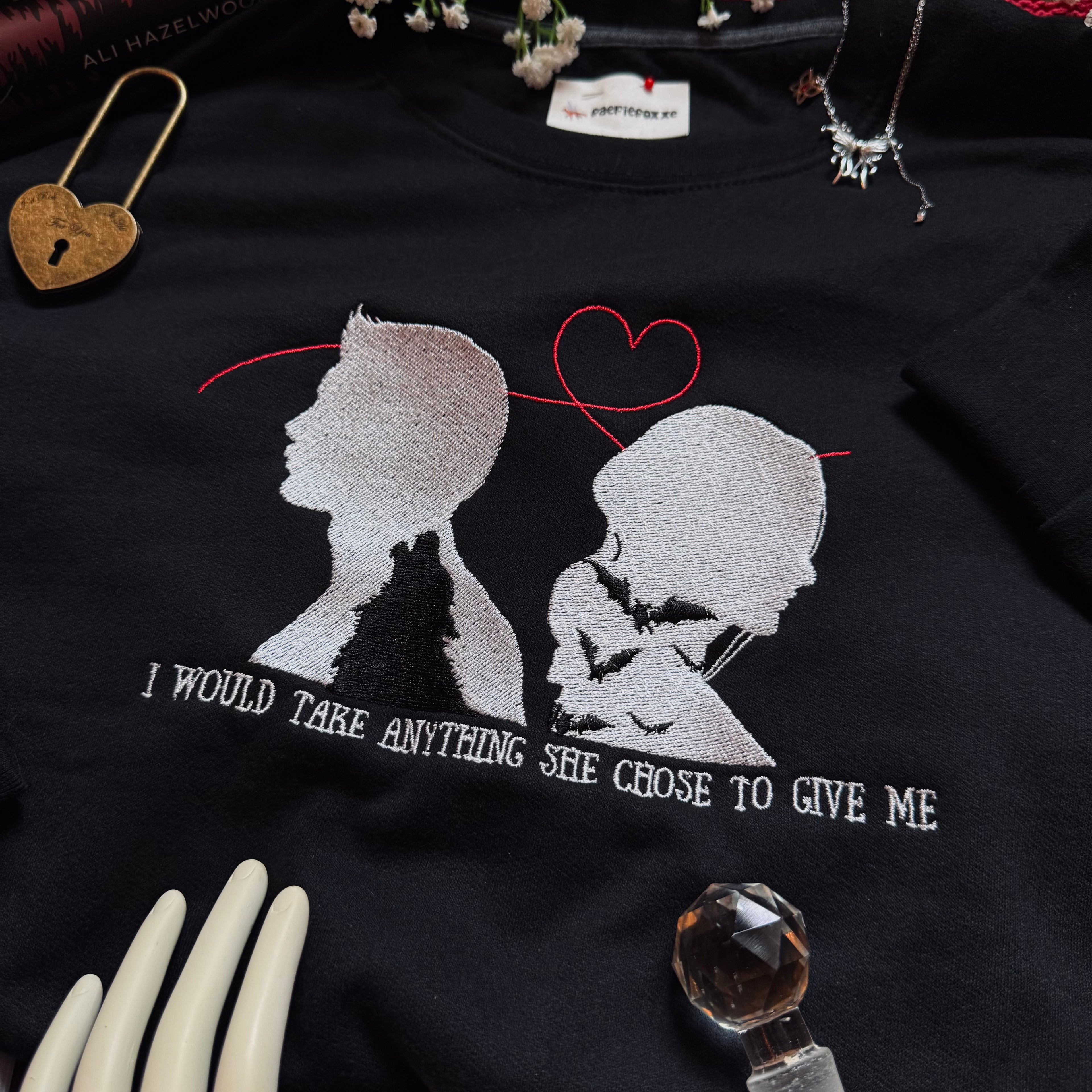 Black sweatshirt with white silhouette design and text on a dark background.