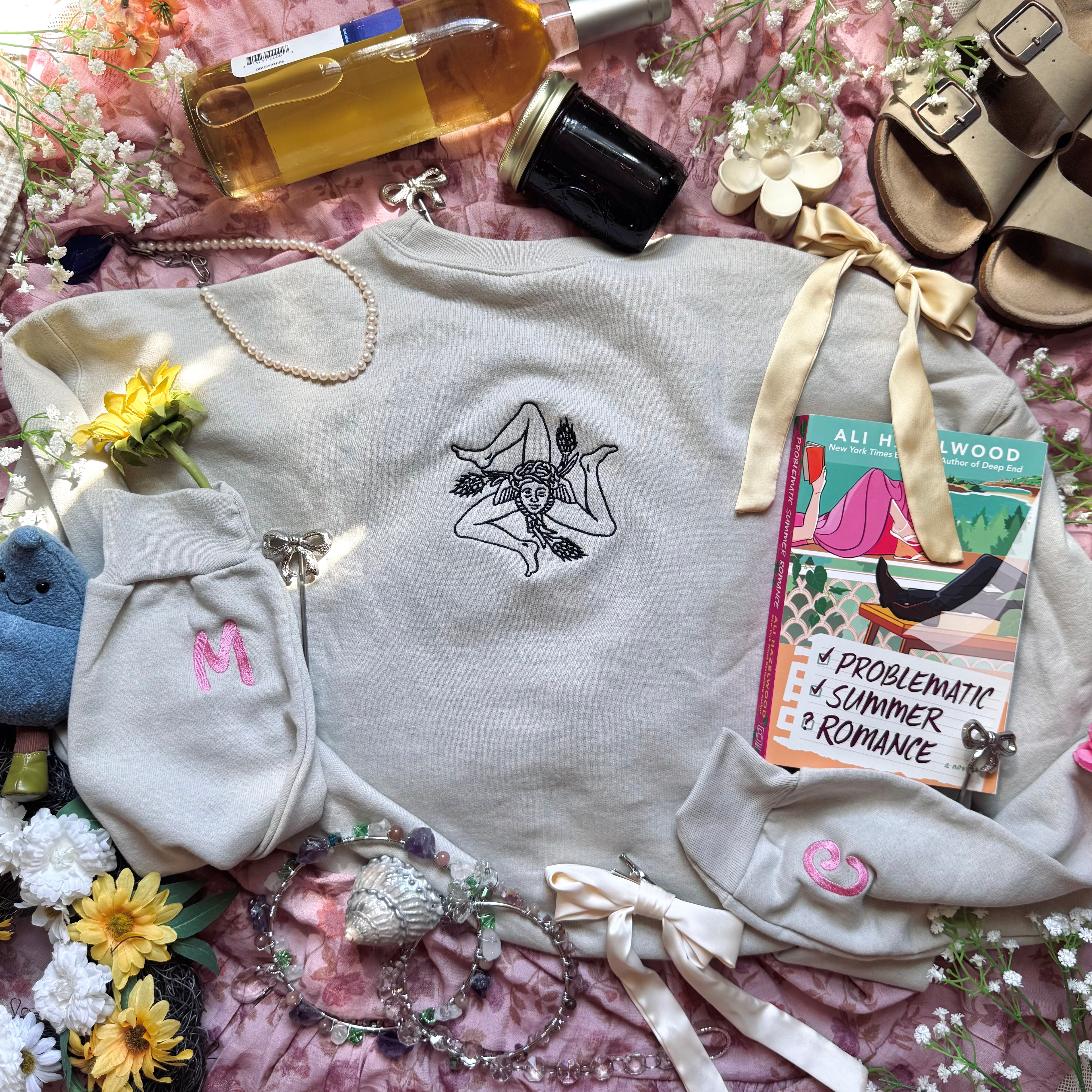 Beige sweatshirt with embroidered design on the back.