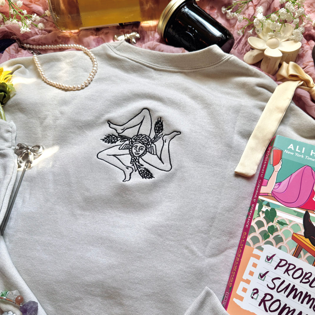 Beige sweatshirt with embroidered design on the back.