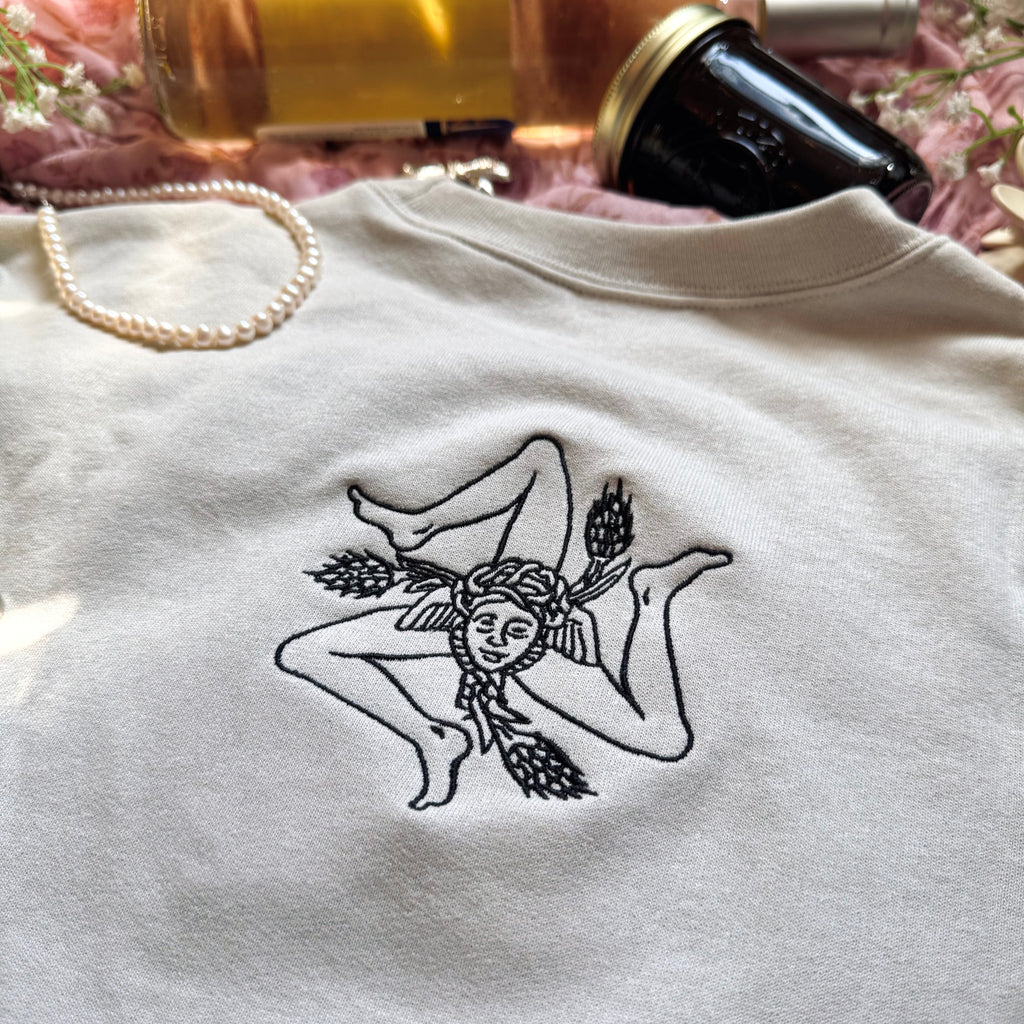 Beige sweatshirt with embroidered design on the back.