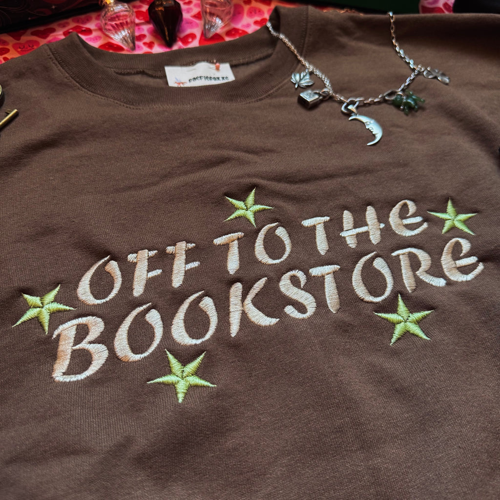 Brown sweatshirt with 'Off to the Bookstore' text and stars.