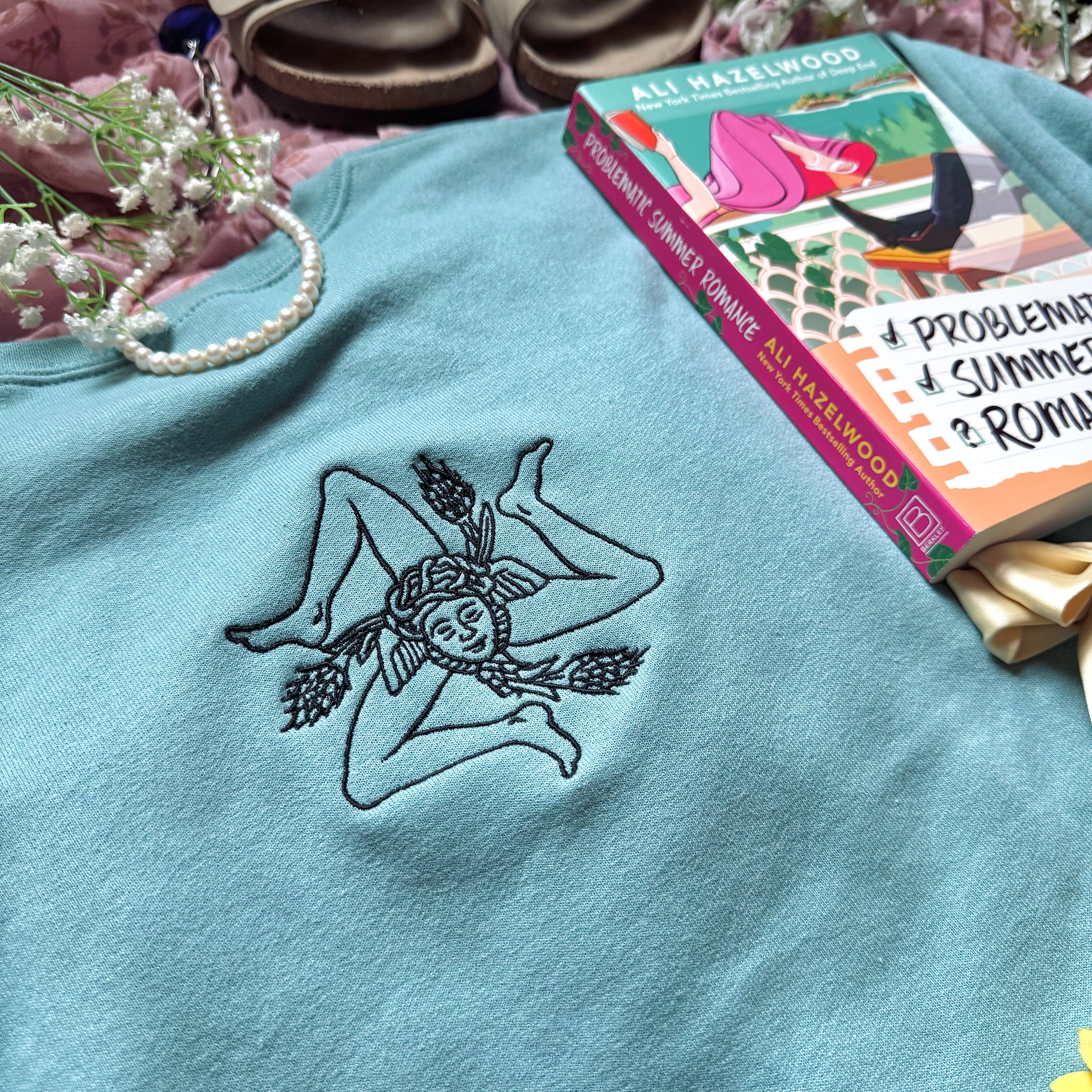 Teal sweatshirt with embroidered design based on Problematic Summer Romance by Ali Hazelwood.